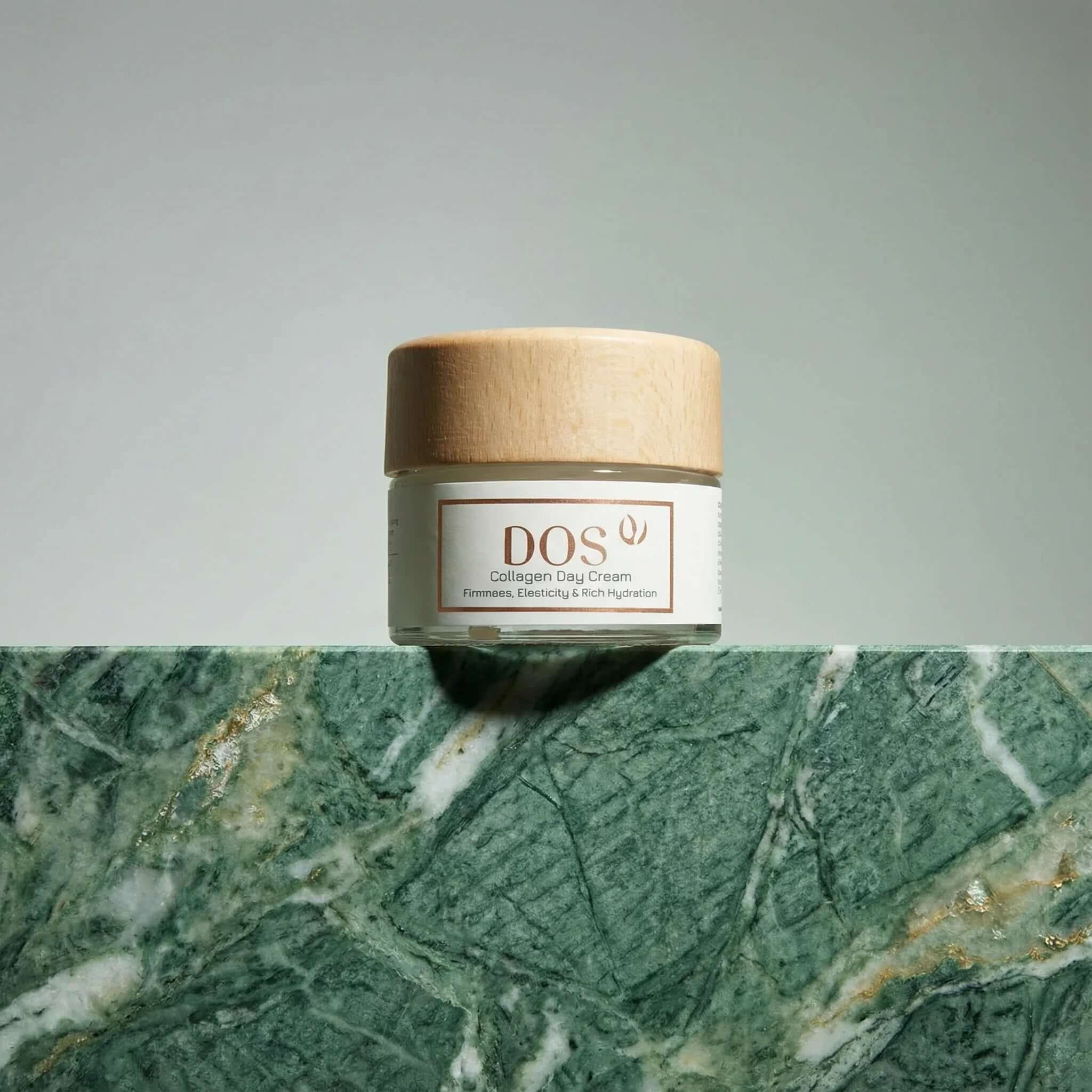 Collagen Day Cream jar displayed on green marble background, showcasing award-winning hydration features. DOS cosmetics
